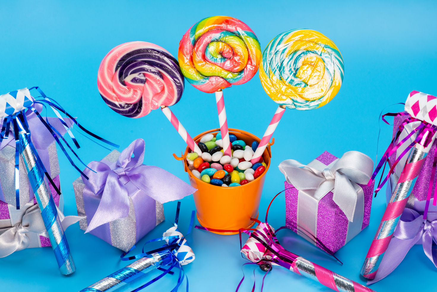 A Front View Lollipops and Candies Colorful Sweet Yummy along with Colorful Gift Boxes and Birthday Whistles Spread All over the Blue Background Confiture Marmalade Sweetness Cake Birthday